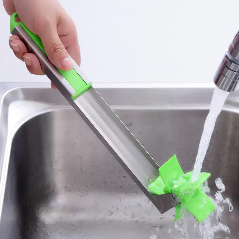 Watermelon Cutter being rinsed under water in a kitchen sink.