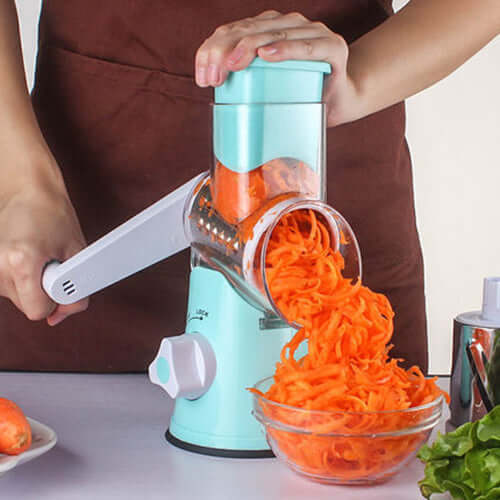 Manual kitchen accessories showing a multifunctional mandoline slicer kitchen gadget shredding carrots into a bowl.
