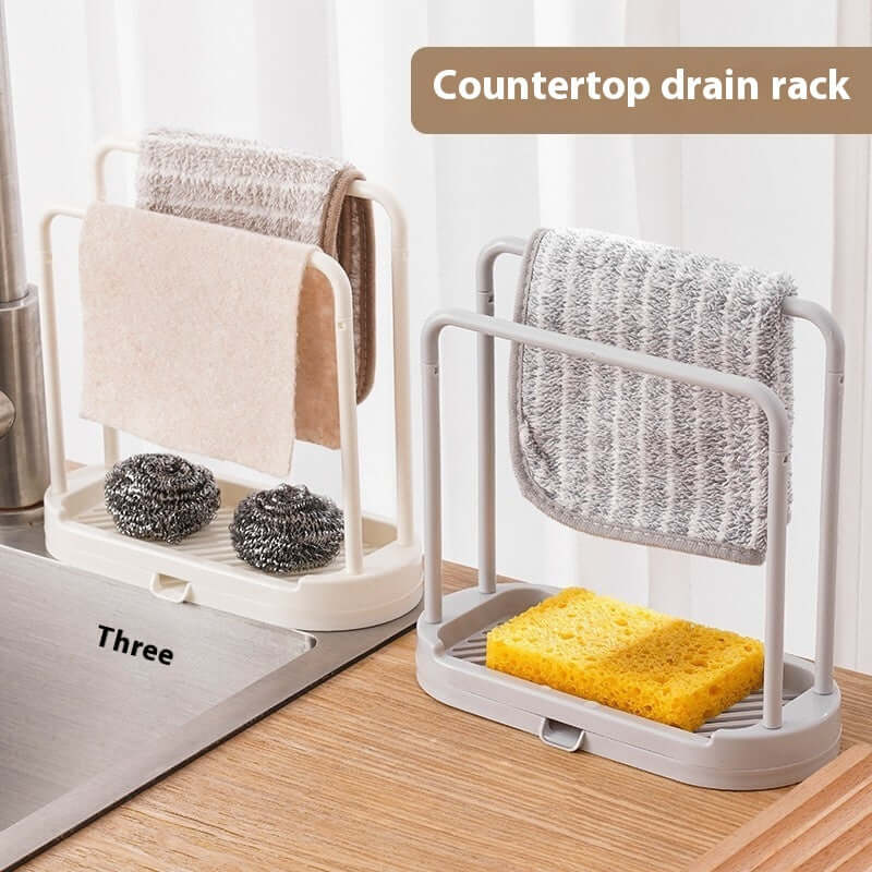 Multi-purpose kitchen drain rack with towels and sponge on a kitchen countertop.