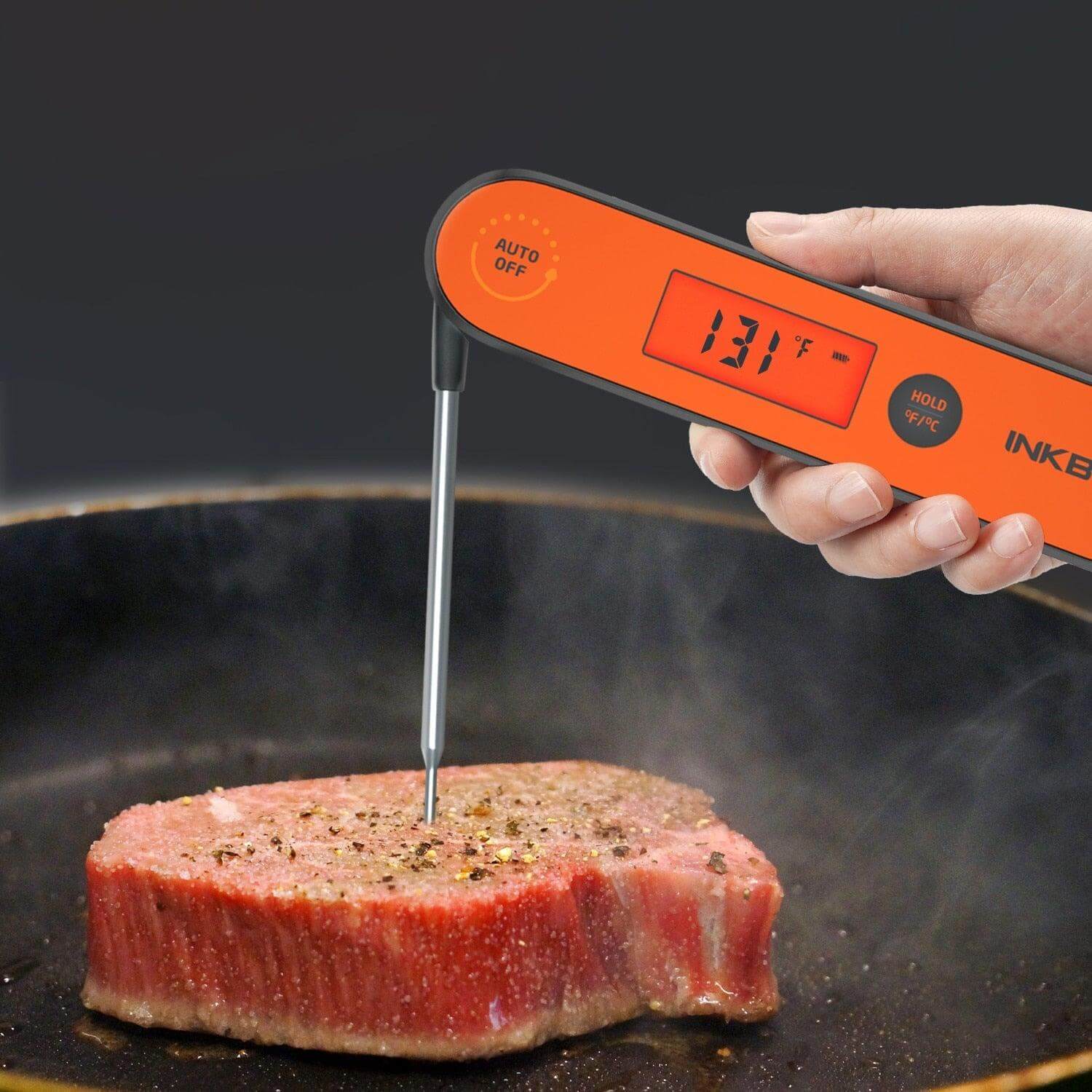Digital BBQ Thermometer measuring internal temperature of steak while cooking.