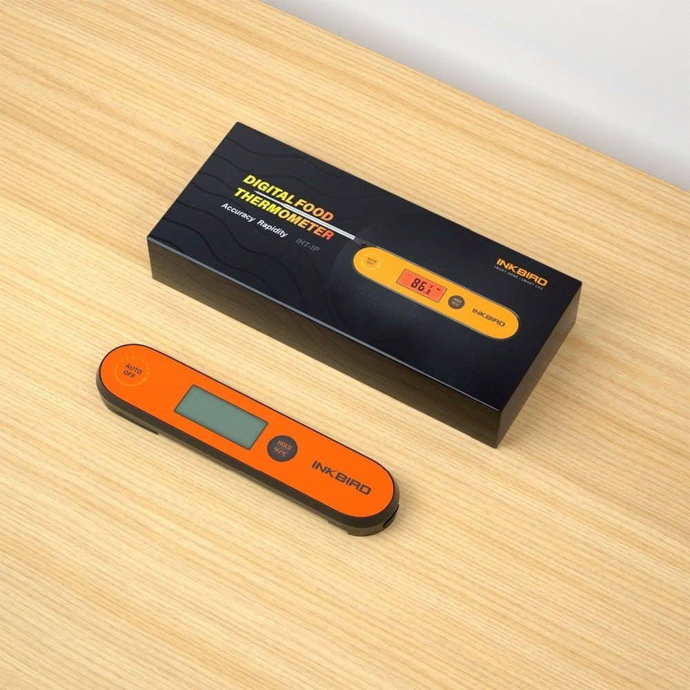 Digital BBQ Thermometer with packaging on wooden surface, displaying accurate temperature reading.