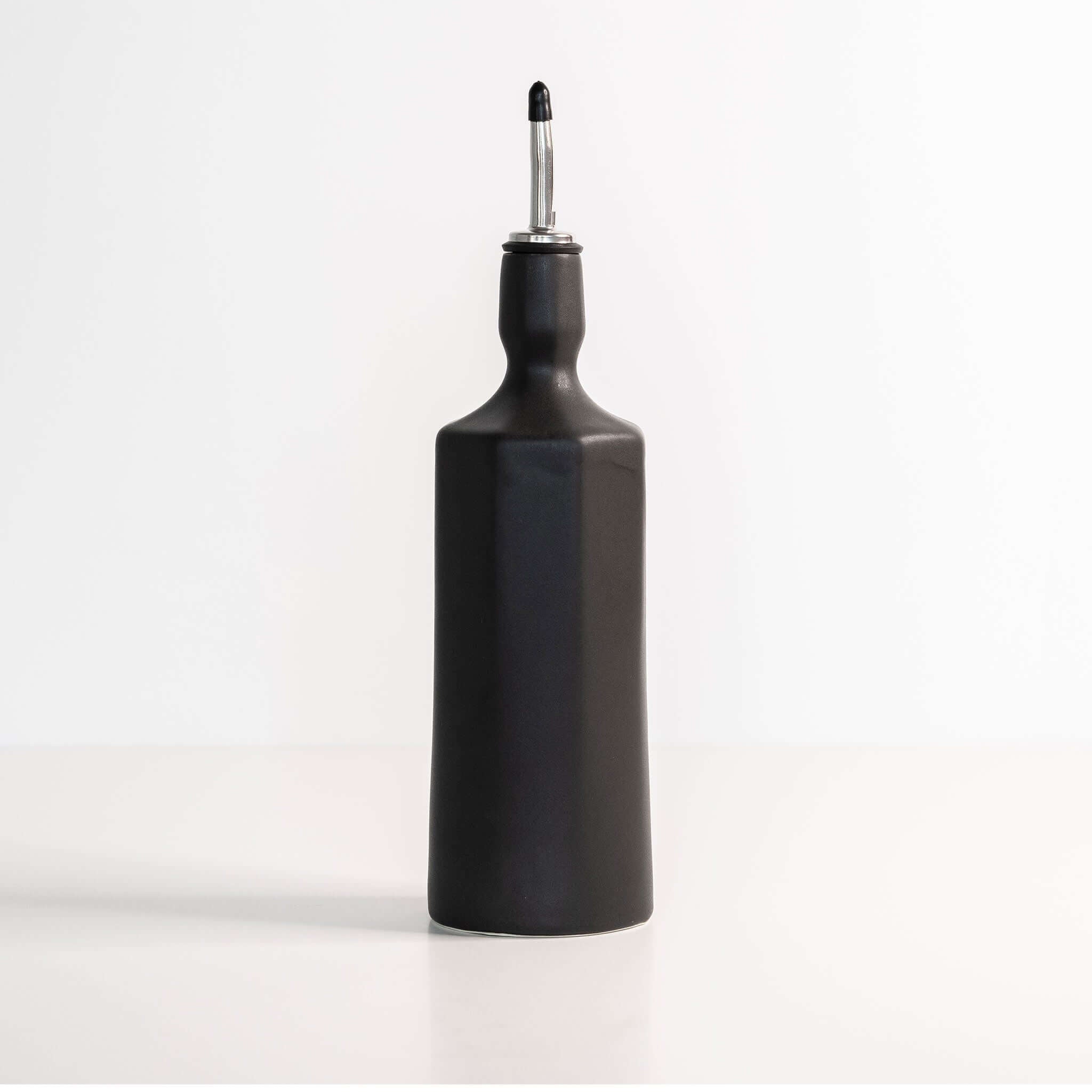 Elixir Porcelain Olive Oil Dispenser in Mica Black ceramic with sleek design for elegant kitchen storage.