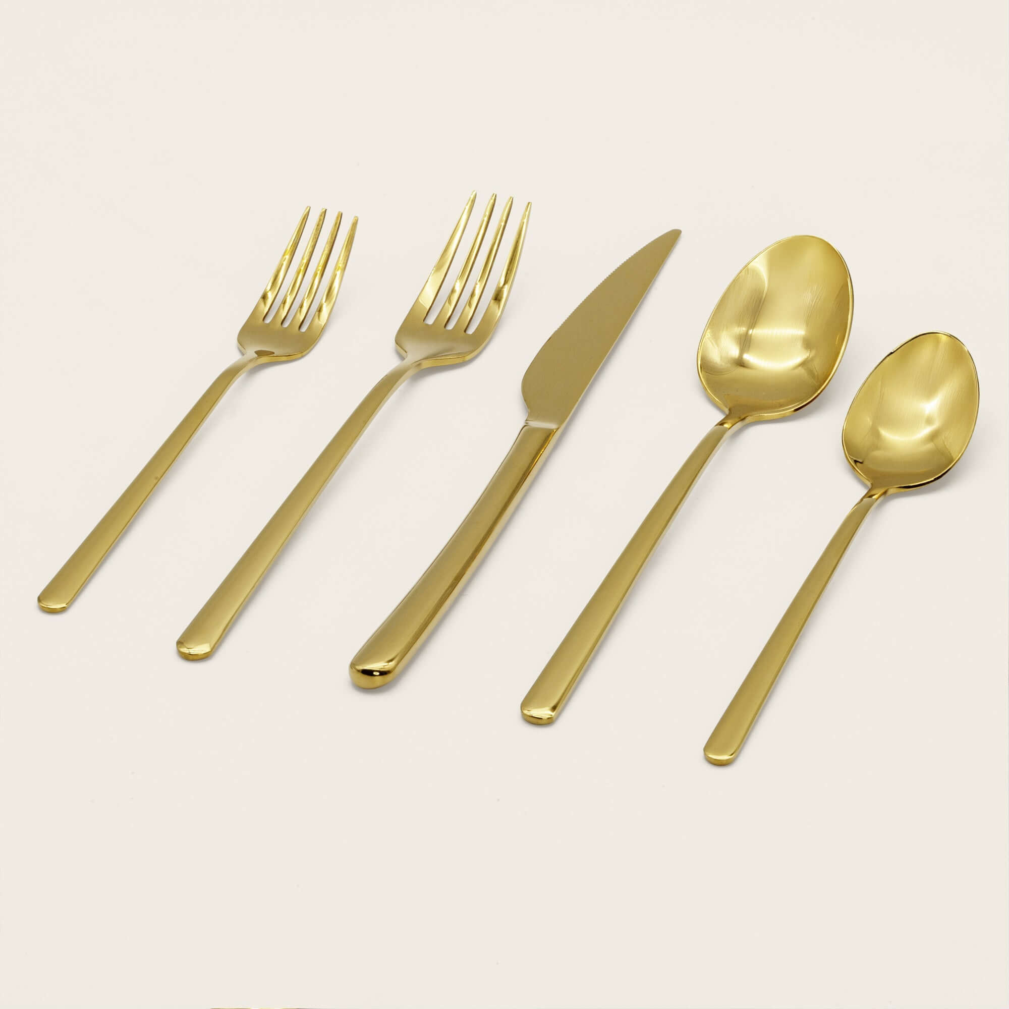 Emilia Mirror 20-Piece Flatware Set featuring elegant gold forks, knife, and spoons arranged on a light background.