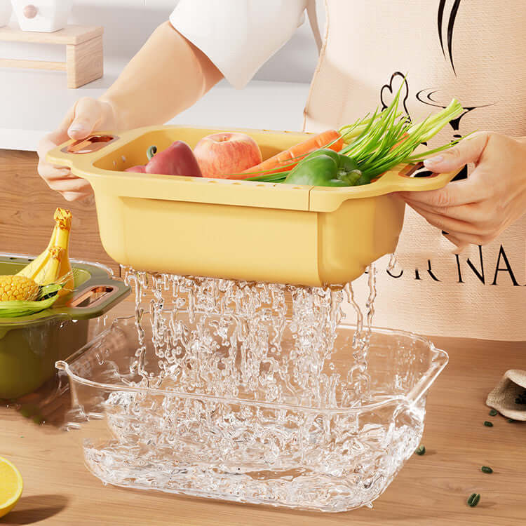 Person holding a yellow Home Kitchen double retractable drainer basket with vegetables, water draining below.